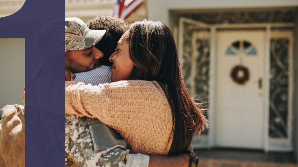 African American military service member hugging family in front of house