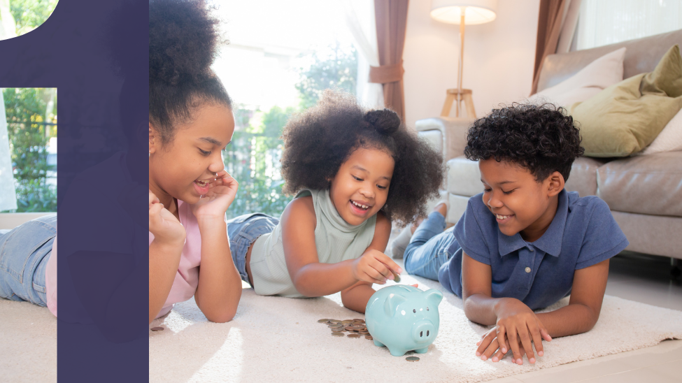 Three happy African American children sitting on the floor putting coins into a piggy bank