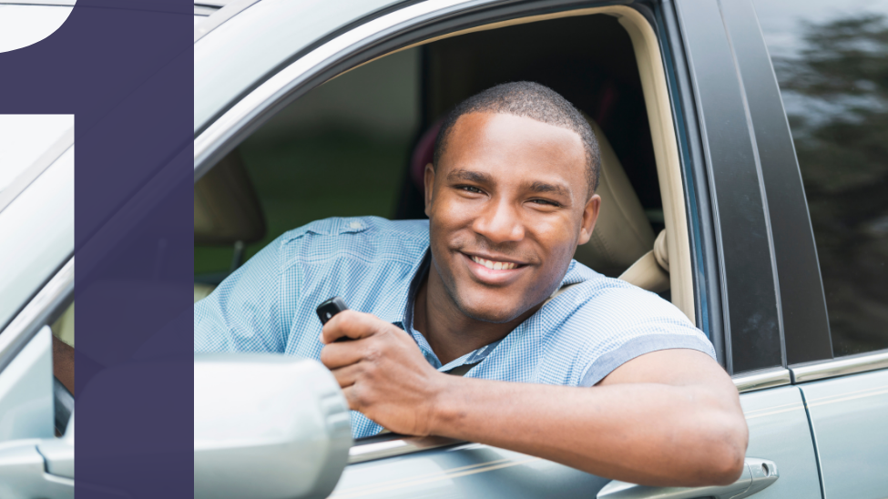 Young black man sitting in driver's seat of a car holding electronic key smiling
